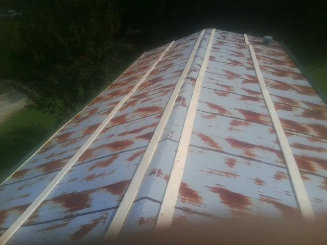 Rusted metal roof panels with new wood purlins before replacement — Storm Damage Roof Repair in Edna by Roofing Brothers