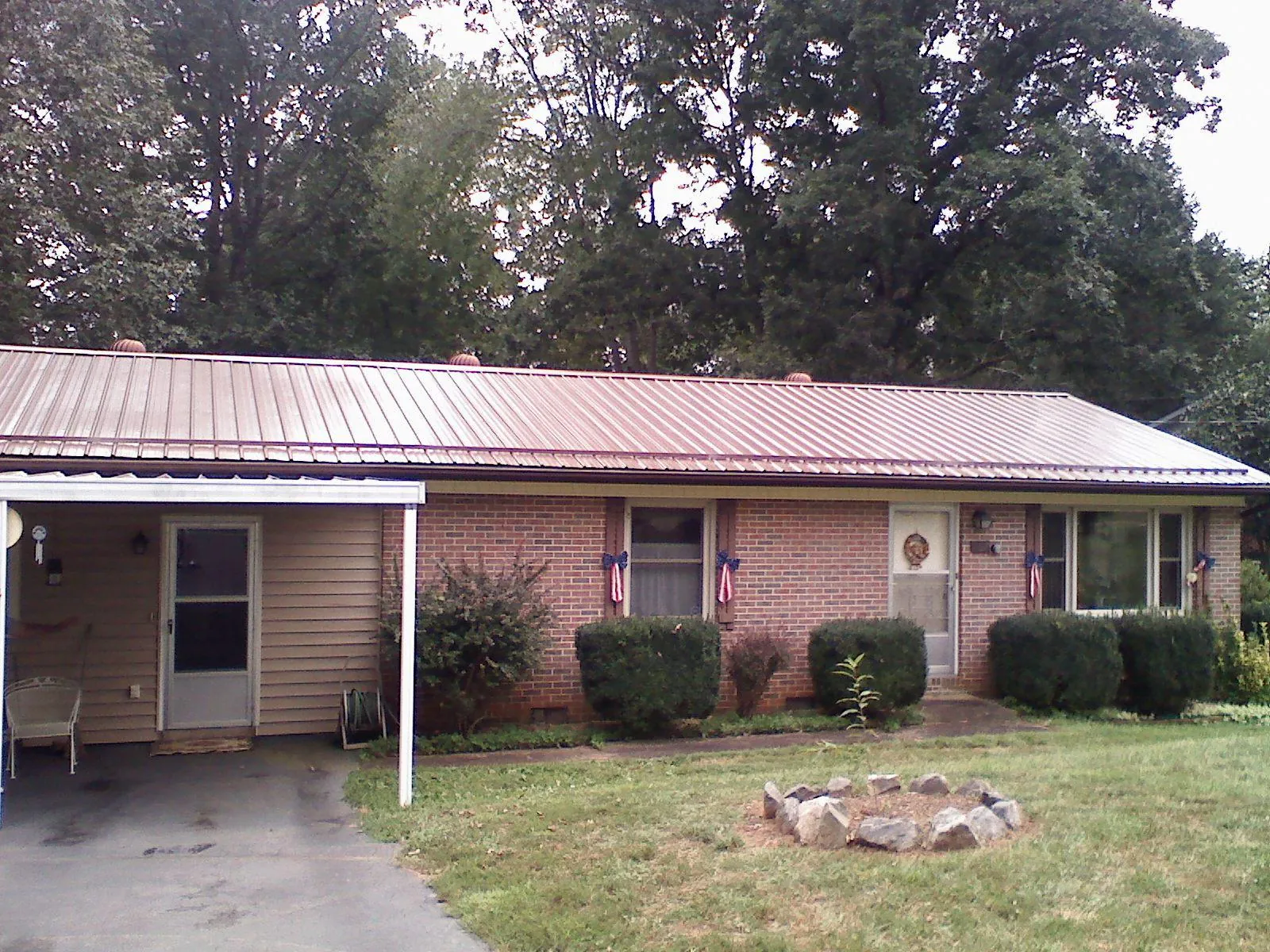 Bronze metal roof and carport on a brick ranch home — Roof Repair work by our crew in Edna