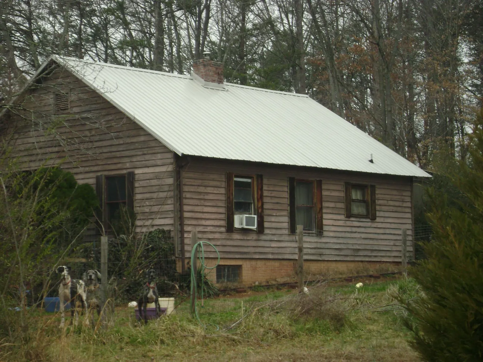White metal roof on an old wood sided farmhouse, from a Metal Roof Installation job in Edna